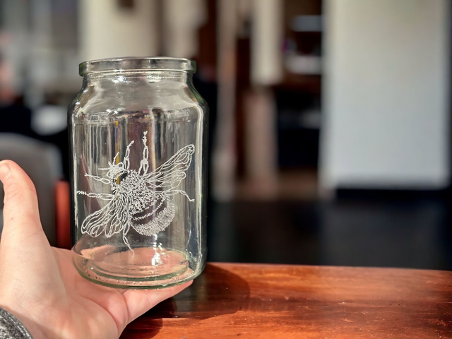 A beautiful small cylindrical glass vase with Bee etching!