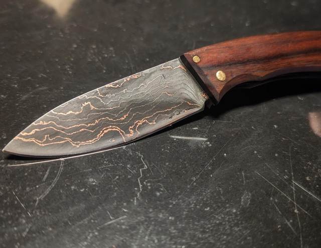 Couteau pliant à cran plat en damas cuivre.
