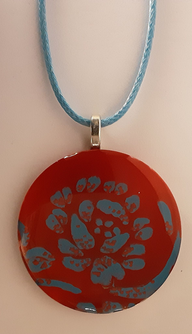 Pendentif rond collection Floral fond rouge flamboyant translucide motif fleurs bleues