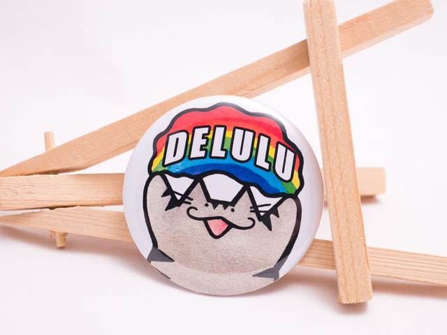 Przypinka DELULU wlepa z burym kotem i wesołym przesłaniem