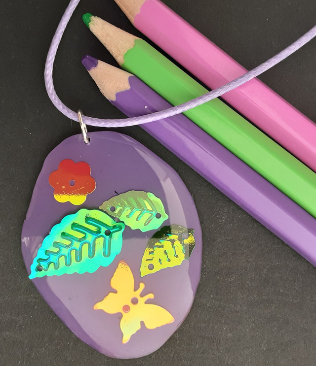 médaillon violet avec papillon et fleurs vertes