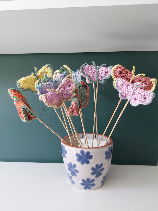 Kukkatikku, kukkapurkkiin, virkattu perhonen tai kukka tikussa