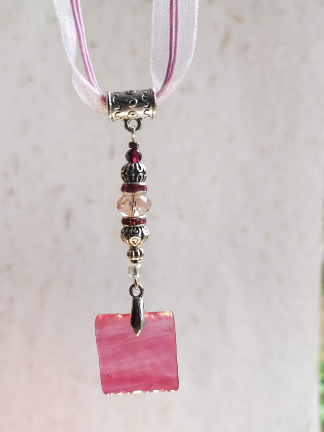 Pendentif en verre rose marbré, texturé et transparent, chaîne en coton rose. 