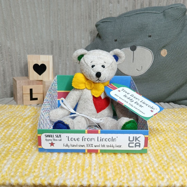 LOVE FROM LINCOLN. Small size, handmade teddy bear. UKCA. Tray base packaging. Standard Wool Felt. Beige. Yellow. Red. Green. Blue. Lincolnshire Flag.