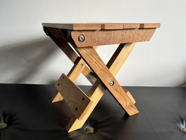 Wooden, folding camping stool made of oak and maple wood.