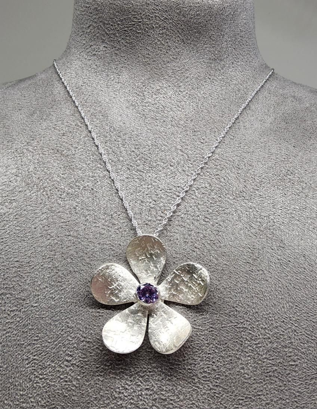 Textured flower pendant with lilac cubic zirconia on silver pendant