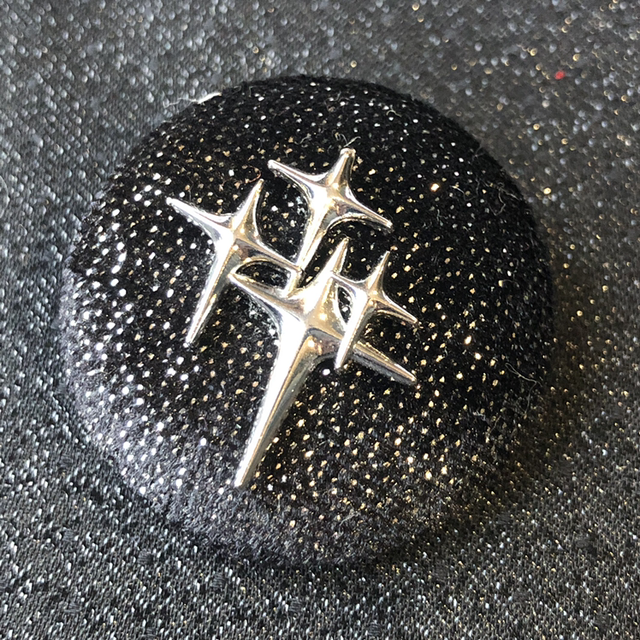 Broche noir paillettée avec ses étoiles atomiques