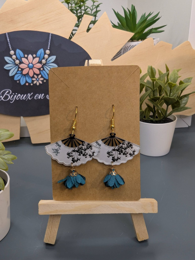 Boucles d'oreilles avec breloque éventail et pompon bleu.