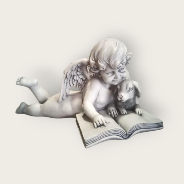 Figurine d’ange couché lisant avec un petit chien