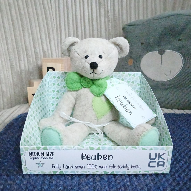 Reuben. Medium size, handmade teddy bear. UKCA. Tray base packaging. Standard Wool Felt. Beige. Green.