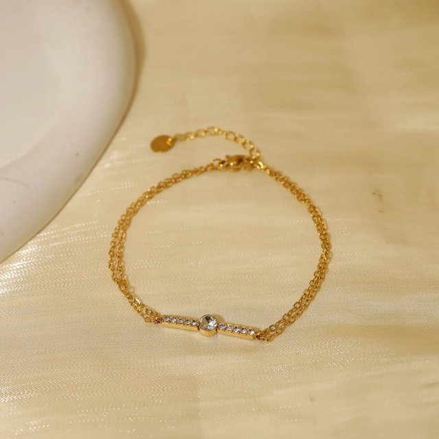 Bracelet double chaîne dorée avec barre en strass