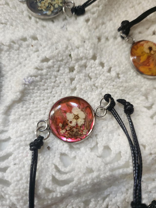 Bracelet fleurs cordon noir fond rose