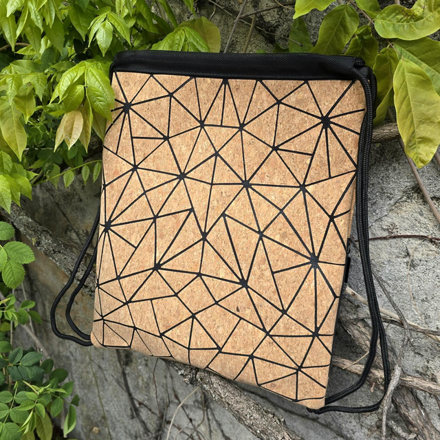 Sac à dos de sport (ou pas) à cordon coullissant en tissu de liège naturel sur fond en toile noir resptirant 