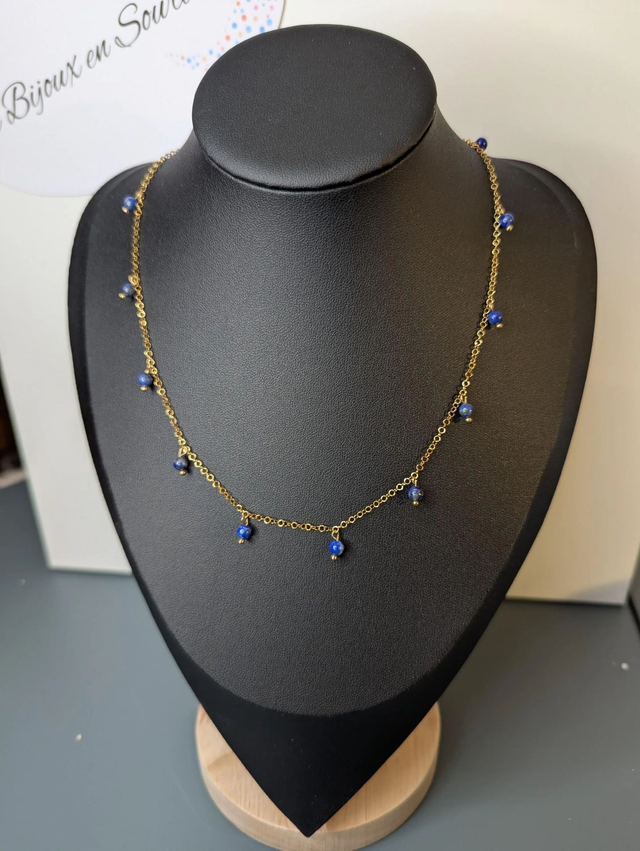collier court avec une chaine en or fine et des perles naturelles de couleur bleu, la chaine fermoir est de couleur or. 