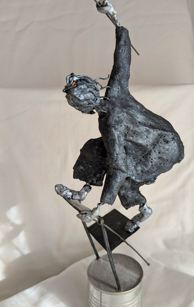 L'équilibriste sur une chaise, sculpture noire et argent