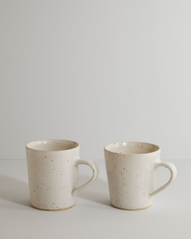 A pair of white speckle mugs