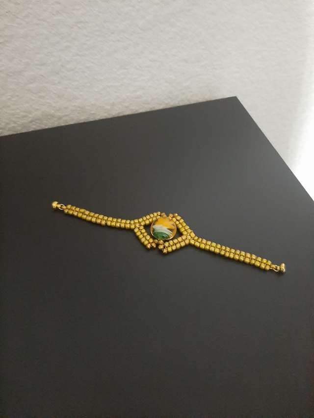 bracelet doré œil verre murano jaune oange , tissé  en  crystal et perles rocailles   fermoir magnétique 		