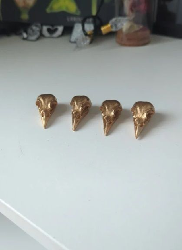 Lot de 4 crânes de corbeau en résine dorée