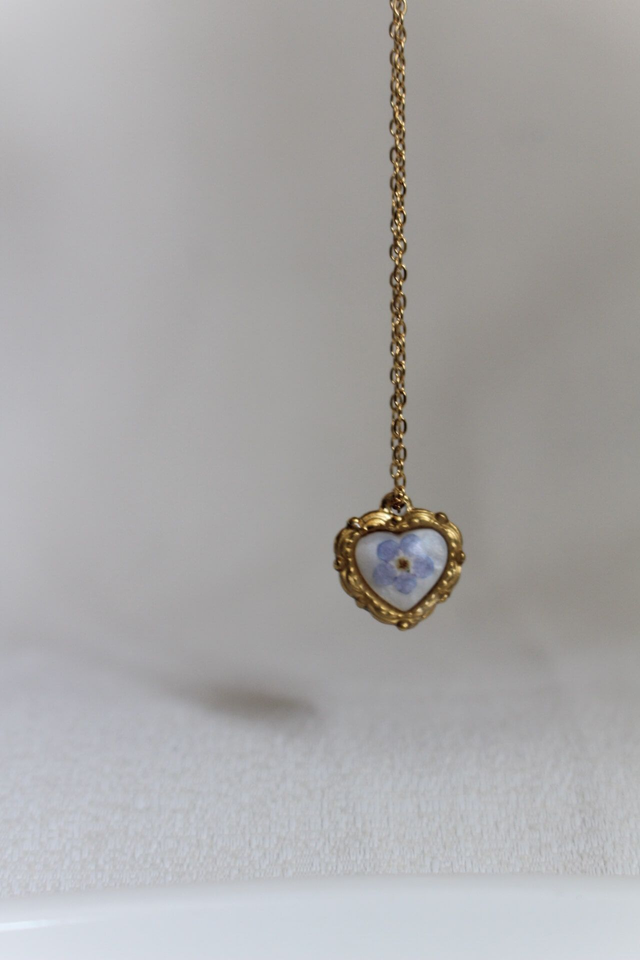Collier coeur en résine contenant une véritable fleur de Myosotis