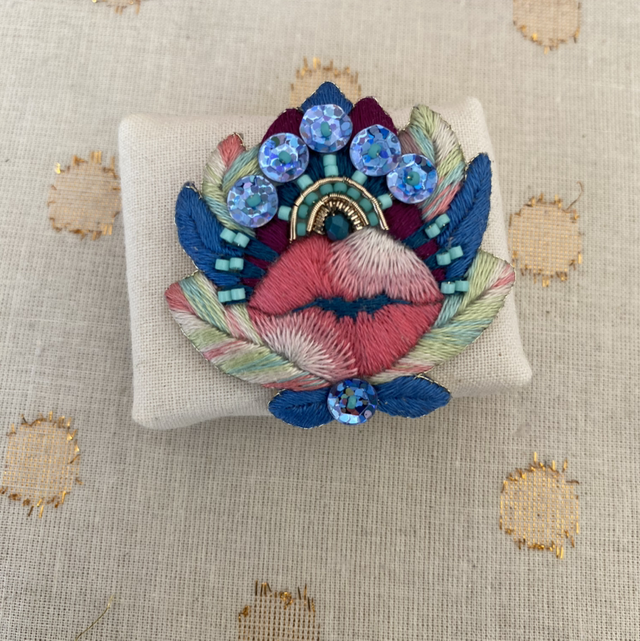 Broche bouche et fleur bleue