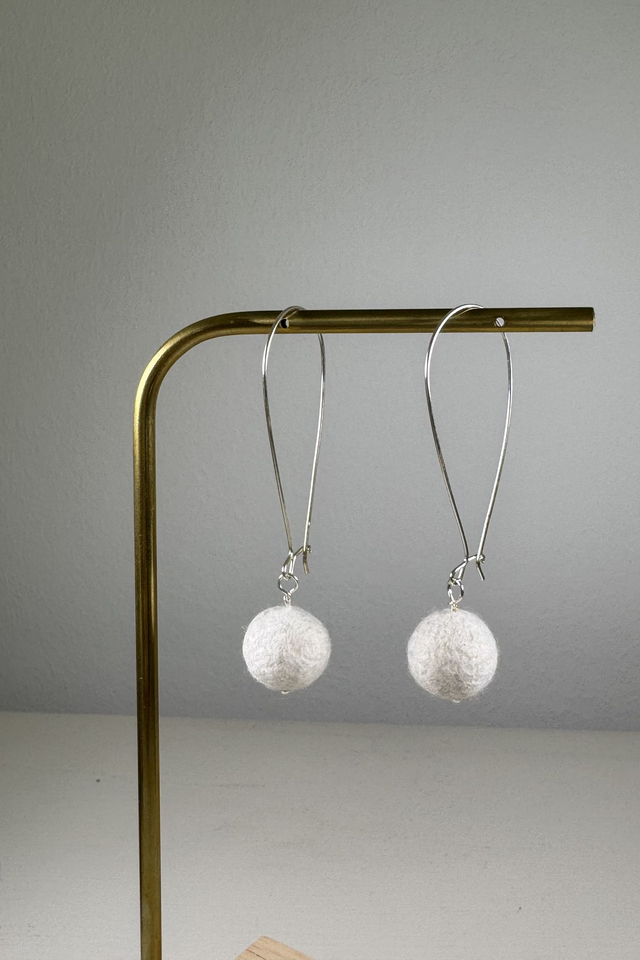 Weiße Filzkugeln an langen Silberohrringen