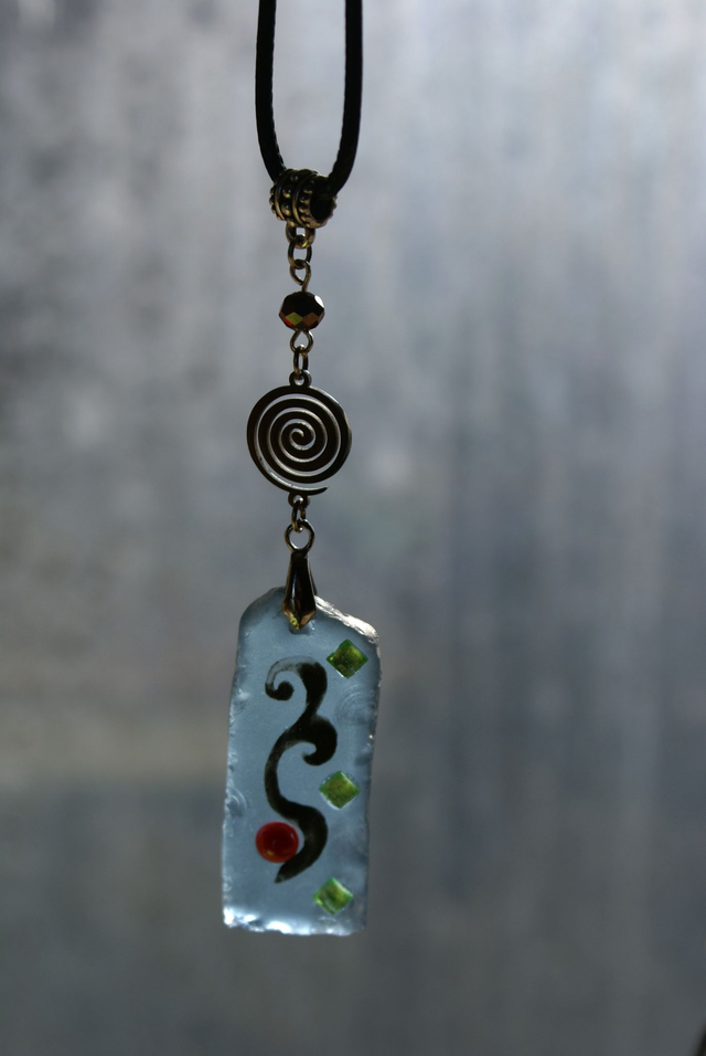 Pendentif en verre bleu clair dépoli et chaîne en coton ciré noir. Numéro 9