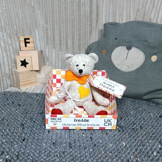 Freddie. Small size, handmade teddy bear. UKCA. Tray base packaging. Fluffy beige. White. Blue. Orange. 