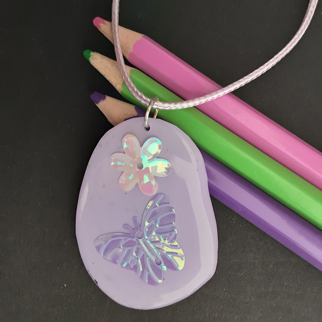 médaillon mauve fleur et papillon irisé