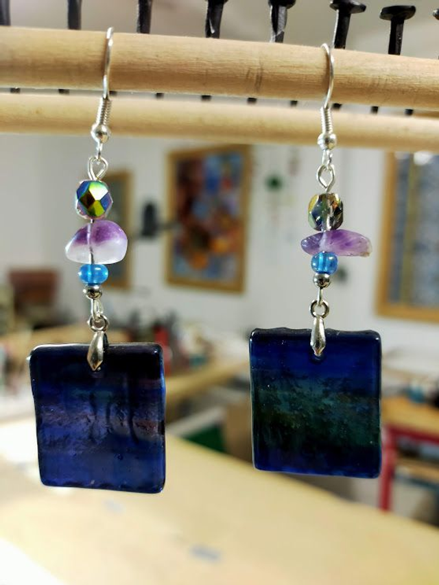 Boucles d&#039;oreilles chamarrées en verre violet, bleu et vert texturé et transparent. 