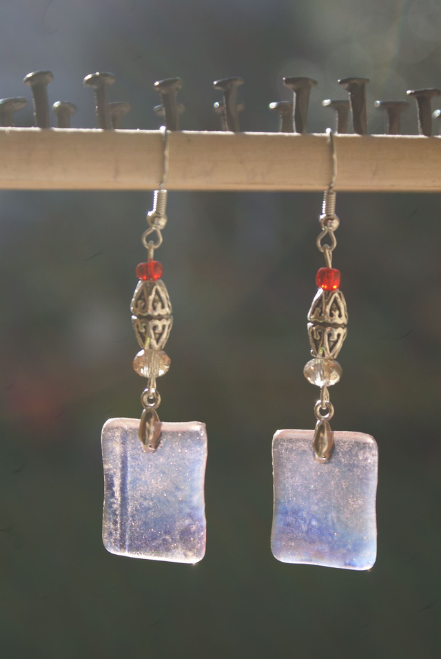 Boucles d&#039;oreilles en verre rose pâle transparent. 