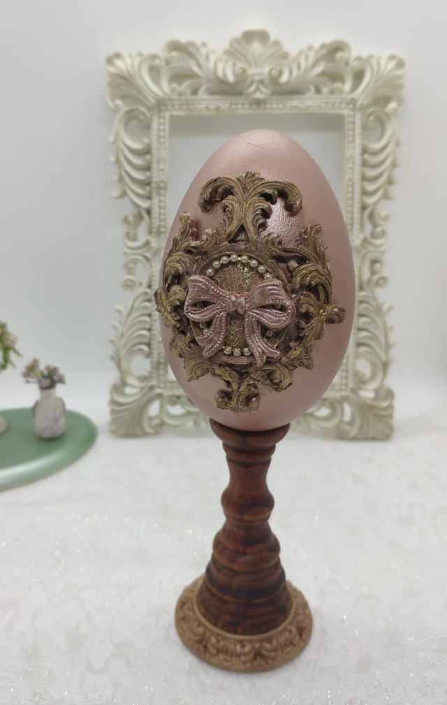 Goose egg with bow on a wooden stand 