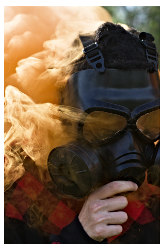Résilience : Portrait d’un homme au masque à gaz dans une fumée orange