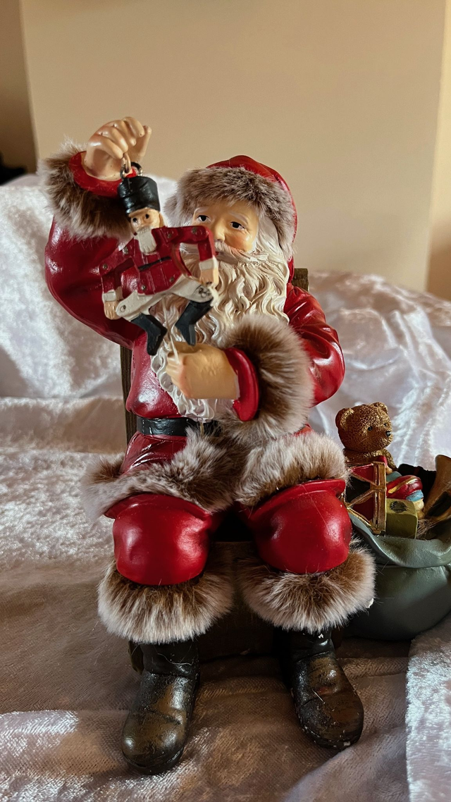 Weihnachtsmann auf Sessel – mit einem Sack mit Geschenken-liebevoll gestaltete Weihnachtsfigur