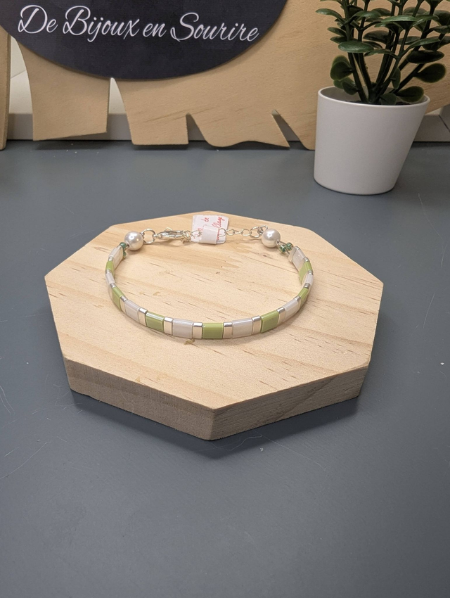 Bracelet en perles plate en verre blanc et vert clair avec des perles d'espacement en métal argenté. Le fermoir et la chaine fermoir sont en argent.