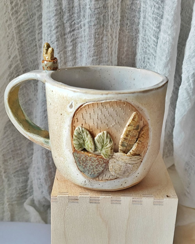 Beżowo-kremowy kubek z roślinami w doniczkach