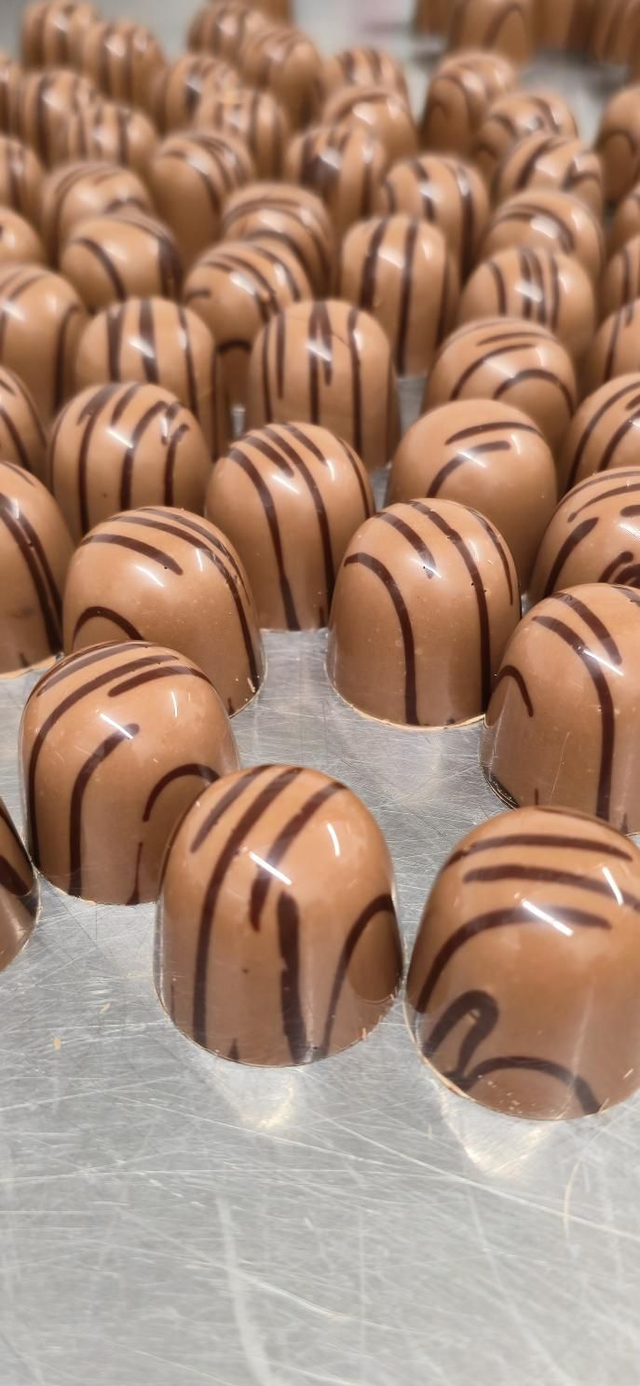 Milk chocolate bonbon with coffee ganache and Pecan praline. 