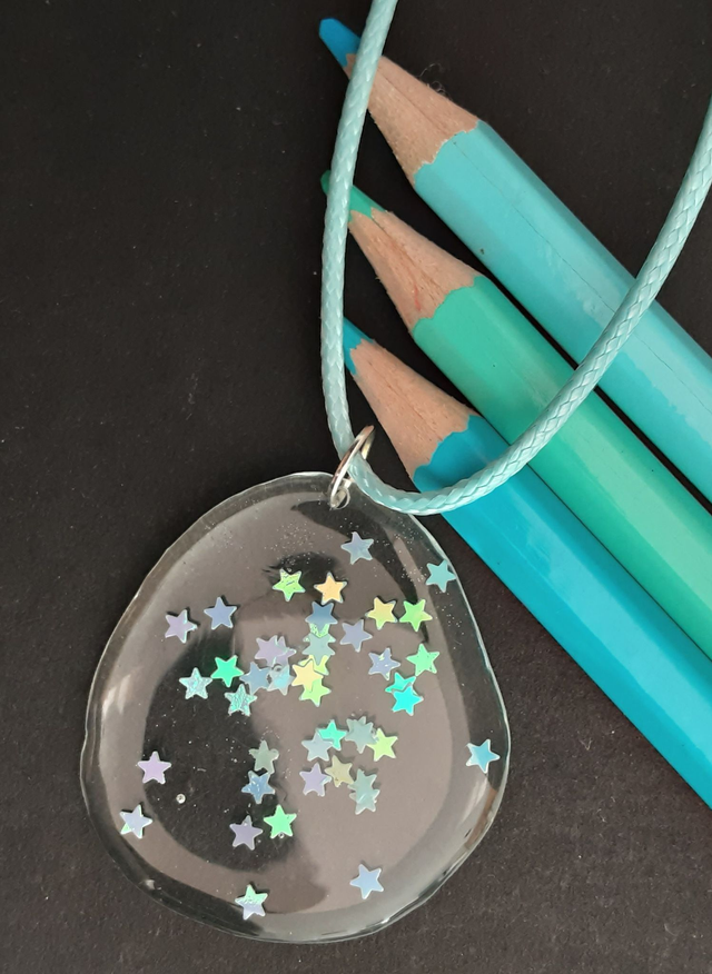 médaillon transparent et étoiles irisées bleues