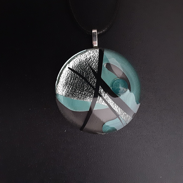 Pendentif rond collection Elégance-fond transparent-décor vert d&#039;eau métallisé-motifs noirs-cabochon vert d&#039;eau