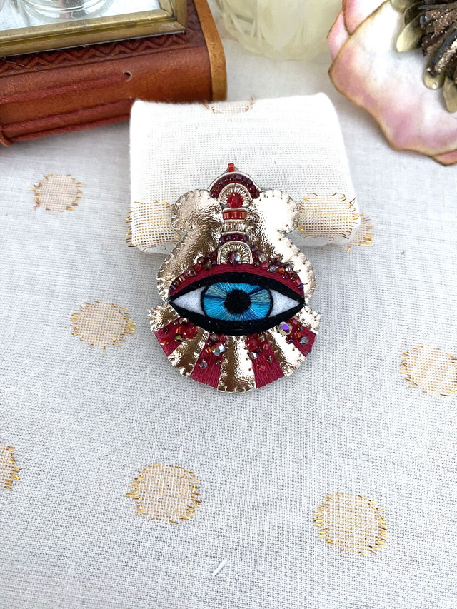 Broche rouge oeil bleu