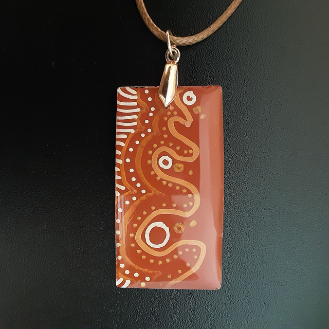 Pendentif collection ethnique fond rouille motifs blancsor