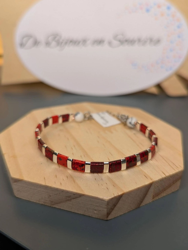 Bracelet en perles plate en verre rouge, perles d'espacement en métal argenté. le fermoir et la chaine fermoir sont en argent. 