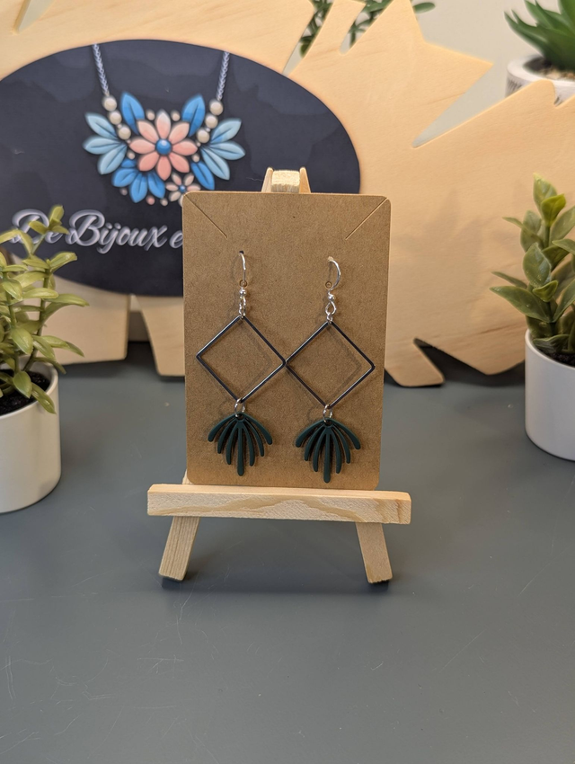 Boucles d'oreilles longue avec pendentif carré et feuille verte.