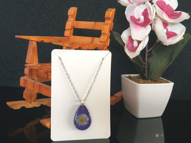 Collier fleur de pâquerette sur fond violet