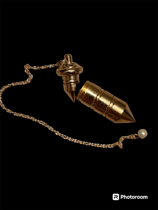 Pendule témoin en laiton massif, doré.