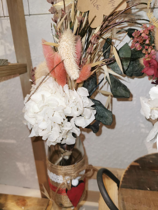 Vase mit rotem Herzanh�nger und Pfauenfeder