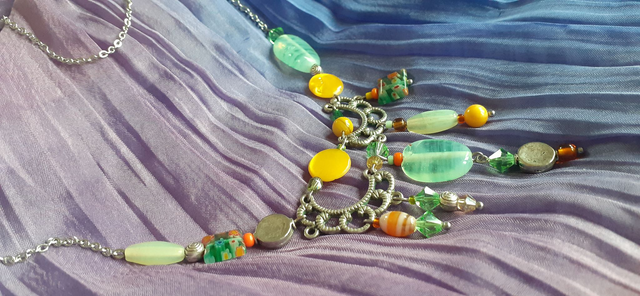 Collier forme plastron, breloques métalliques et perles diverses, ton jaune d'or, vert d'eau