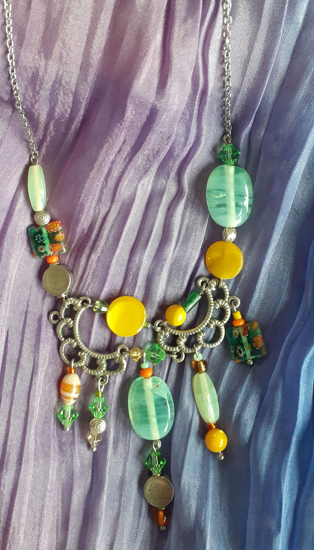 Collier forme plastron, breloques métalliques et perles diverses, ton jaune d'or, vert d'eau