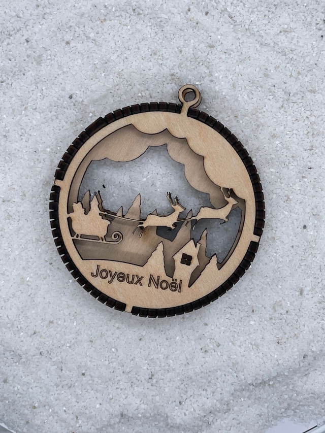 Boule de Noël en bois motif Traîneau et Rennes dans le ciel.