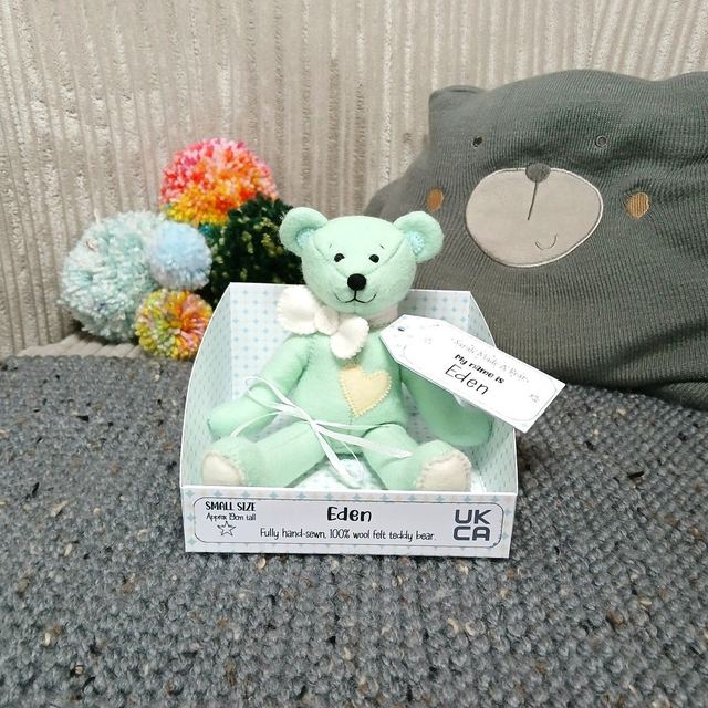 Eden. Small size, handmade teddy bear. UKCA. Tray base packaging. Standard Wool Felt. Pastel green. Light yellow. Cream. White.