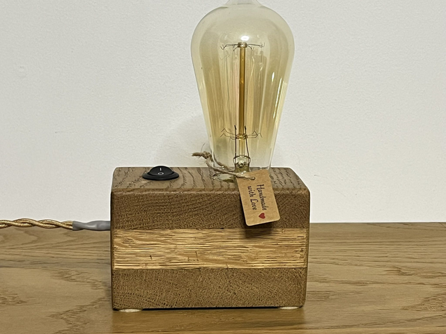 Rustic bedside lamp made of oak wood with a switch and an Edison bulb.